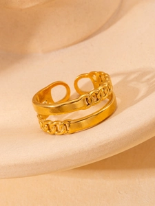 Detail of a layered golden titanium steel ring featuring a chain link texture and open band