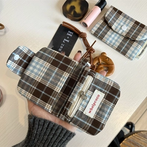 Detail of vintage plaid card holder featuring canvas fabric and silver zipper closure