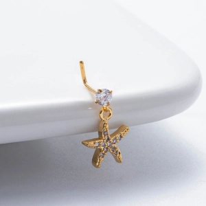 Vue macro d'un piercing nez avec pendentif étoile de mer doré et zircons brillants