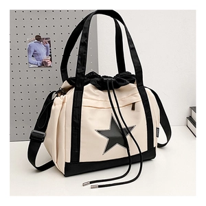 Detail of canvas tote bag with star logo, drawstring closure and fashion strap