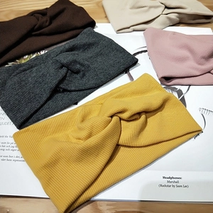 Knitted wide twist headband set in various autumn colors on a wooden surface