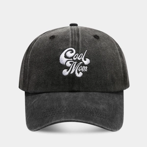 Close-up of Cool Mom embroidery on a washed charcoal grey cotton baseball cap