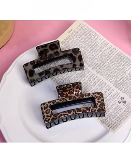 Detail of square leopard print hair claws in brown and gray tones on a vintage tray