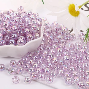 Close-up of 8mm purple glitter acrylic beads spilled from a white bowl for DIY crafts