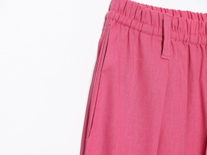 Gros plan détaillé du pantalon en lin rose montrant la taille élastique et les coutures
