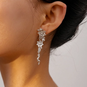 Close-up of silver floral tassel earrings with realistic metal textures and droplets