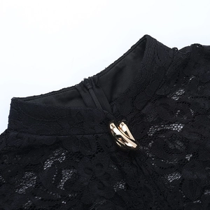 Détail du col en dentelle noire avec anneaux dorés et fermeture éclair invisible