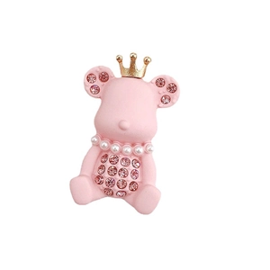 Pink bear charm with golden crown, pink rhinestones and pearl necklace on white background