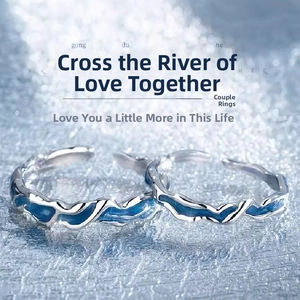 Close-up of angel and demon couple rings with blue water ripple enamel finish