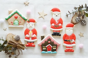 Detailed close-up of festive gingerbread house and Santa Claus cookies with icing textures
