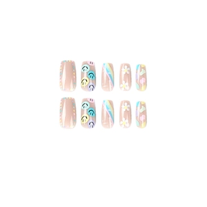 Press-on nails with colorful smiley faces, rainbows and white flowers on pink base