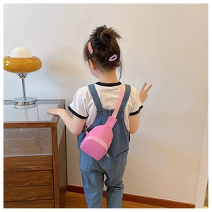Rear view of a child wearing a stylish pink crossbody chest bag against a cozy home interior