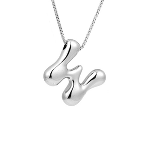 Macro detail of silver liquid metal letter H pendant with high gloss reflection