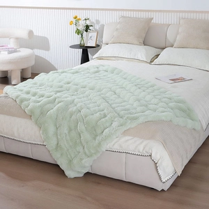 Detail showing wave textured light green faux rabbit fur blanket on a white bed