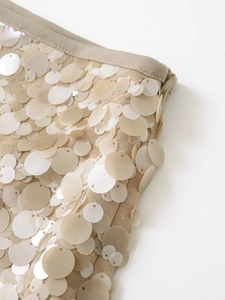 Detailed macro view of champagne sequin A-line skirt featuring side zipper and hem finish