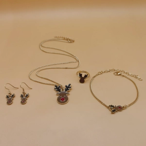 Detailed flat lay of golden reindeer necklace, earrings, ring and bracelet set for Christmas