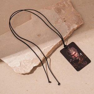 Detailed close-up of Black Myth Wukong pendant on natural rock background with woven cord