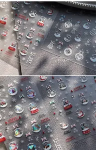Macro shot of 5D Christmas nail stickers with Santa Claus and snowflake relief details