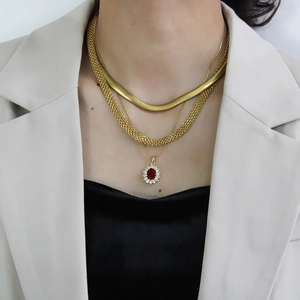 Detail of layered gold 6mm snake chain and necklace set with red gemstone pendant