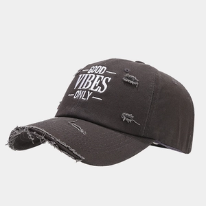 Detail of distressed baseball cap featuring vintage embroidery and ripped edge effects