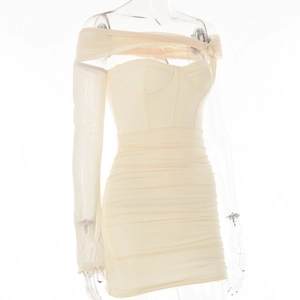 Dettaglio dell'abito a corsetto crema con spalle scoperte e maniche in mesh a pieghe