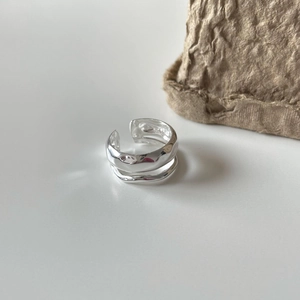 Irregular textured 925 sterling silver open ring shown with a minimalist paper bag background