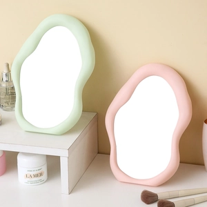 Irregular cloud-shaped vanity mirrors in pastel green and pink with matte plastic frames