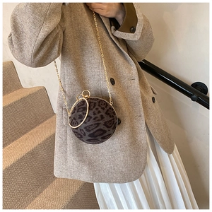 Close-up of leopard print ball bag with gold ring handle and chain strap for evening