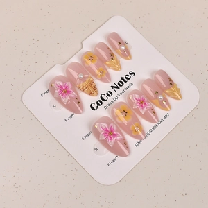 Detail of almond press-on nails with 3D cherry blossoms, pearls, and shell texture