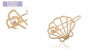 Macro shot of gold shell hair clip with bead edges and white faux pearl detail