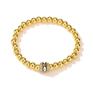 Detail of 18K gold-plated beaded bracelet with crystal-studded evil eye charm