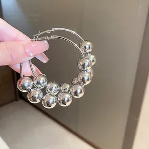 Boucles d'oreilles créoles argentées avec de grandes perles mobiles pour un style chic