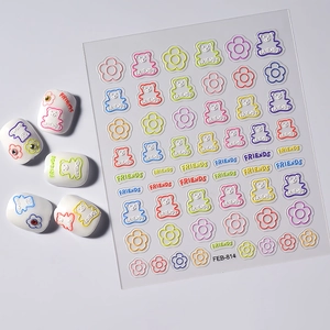 Macro detail of 3D embossed nail stickers featuring colorful bears and floral patterns
