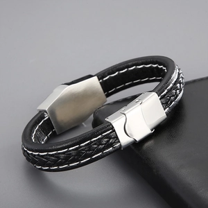 Macro detail of men's braided leather bracelet with stainless steel clasp on leather