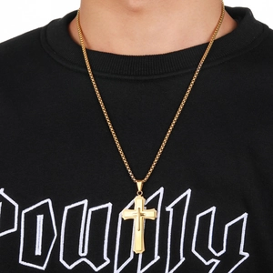 Close-up of a three-layer gold stainless steel cross pendant necklace worn by a model