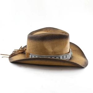 Close-up of woven straw cowboy hat featuring ethnic pattern band and turquoise bead detail