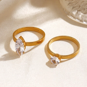 Two gold stainless steel rings featuring marquise and round cut zircon on textured fabric