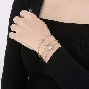 Three-piece stainless steel bangle set in gold, rose gold, and silver with crystal accents