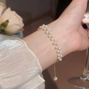 Gros plan d'un élégant bracelet double rangée de perles avec chaîne dorée réglable