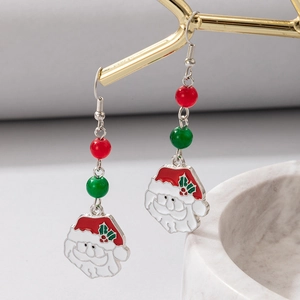 Detail of colorful pearl Christmas Santa earrings on a gold branch with marble tray