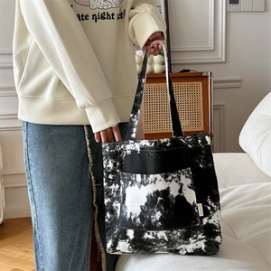 Dettaglio della borsa tote in tela con schizzi d'inchiostro bianco e nero e tasca frontale