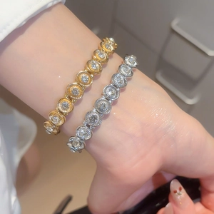 Close-up of gold and silver geometric oval bracelets with sparkling crystals on wrist
