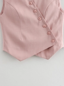 Close-up of asymmetrical button-down closure and collar detail on pink vest top