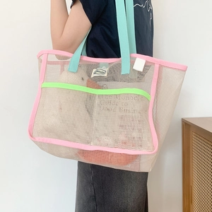 Detail of summer mesh beach tote bag featuring pink edges and mint green straps