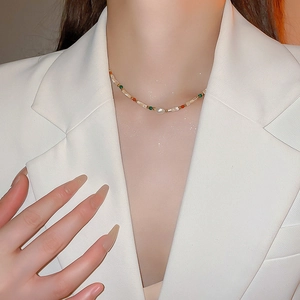 Gros plan du collier de perles colorées et perle irrégulière sur le cou d'une femme