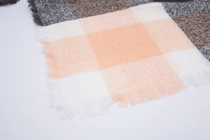 Close-up of pink and grey plaid scarf featuring soft fringe and detailed fabric texture