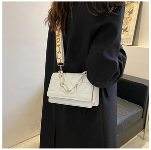 Close-up of white embossed crossbody bag with wide logo strap and metallic chain detail