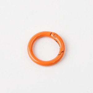Detailed view of an orange round metal spring ring buckle for keychains and accessories