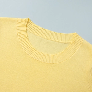 Detail of the crew neck collar and fine knit texture on a bright yellow knit set
