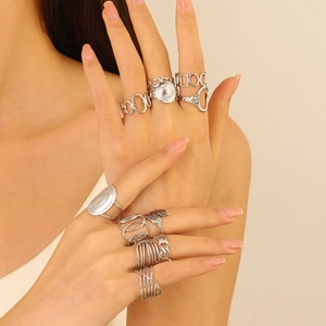 Close-up of bohemian silver stacking rings set featuring geometric and feather designs
